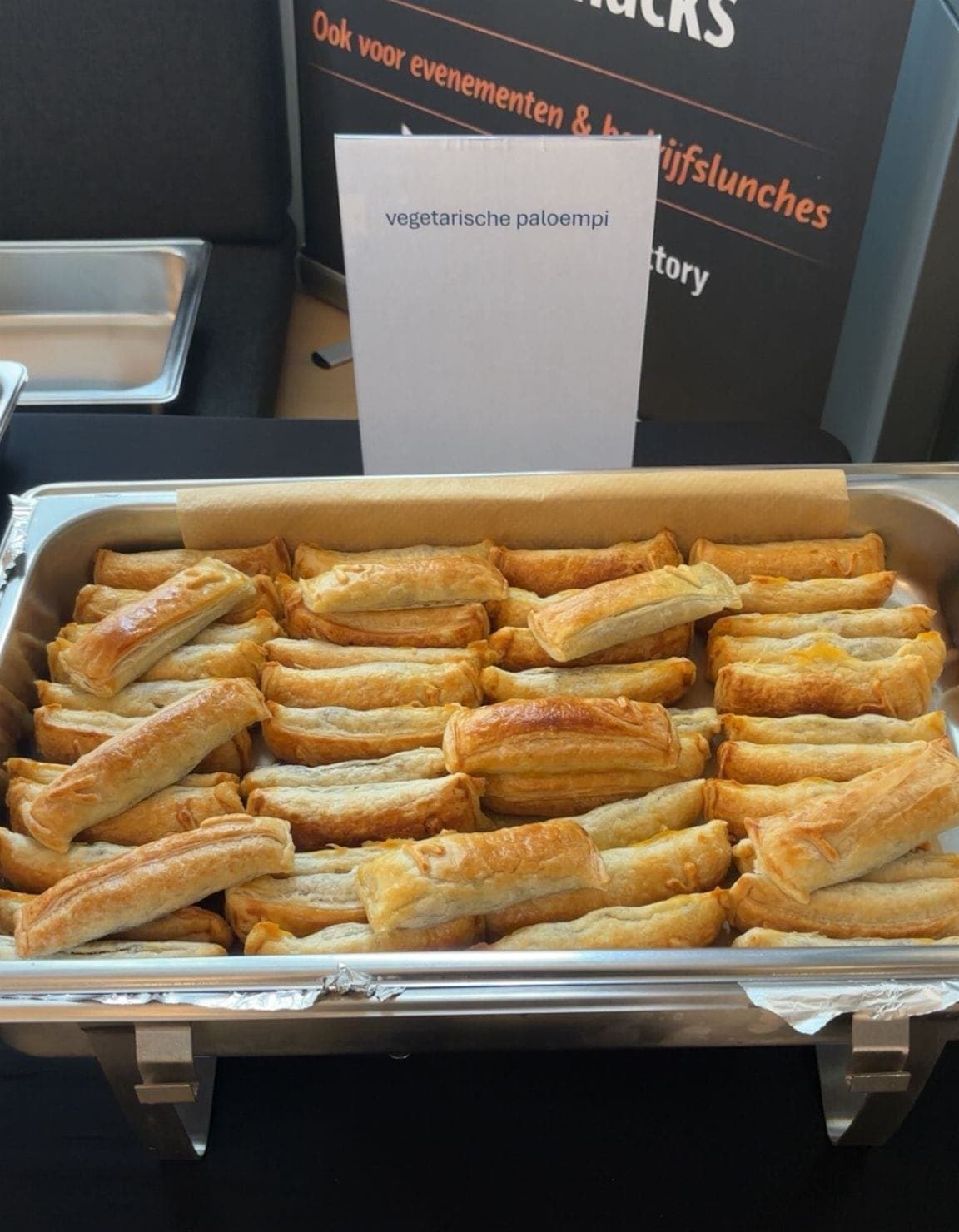 Een bak vegetarische Paloempies op een buffet, met een bordje ernaast waarop staat dat het de vegetarische zijn