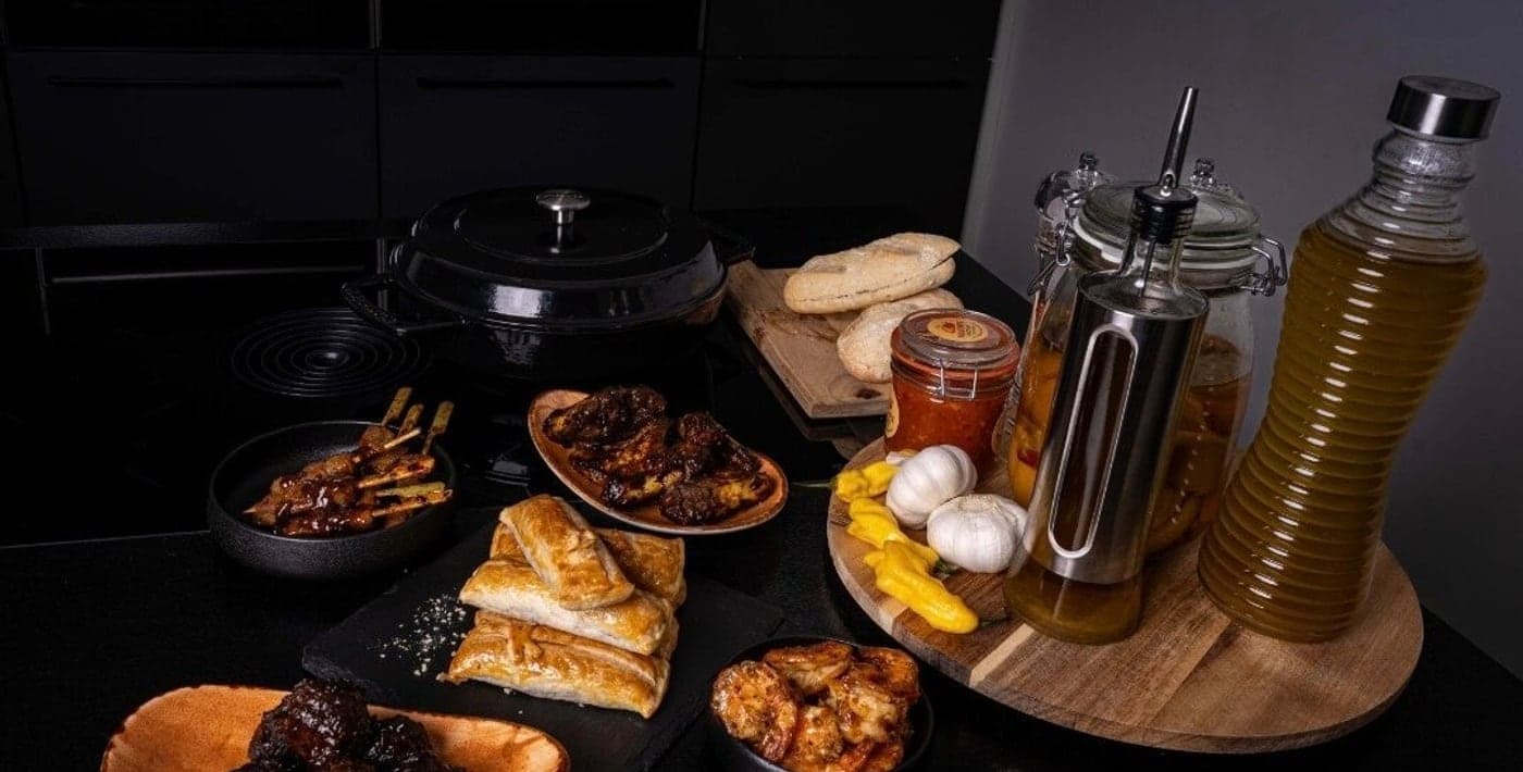 Paloempies, kippenvleugels en gamba’s aangericht op een donkere tafel